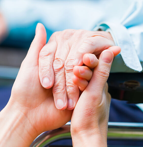Hands of a younger person helping an older one